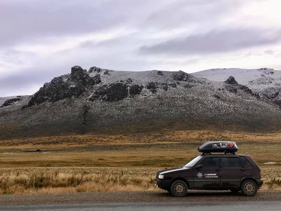 Fiat Uno motorhome em frente a montanhas nevadas na Cordilheira dos Andes